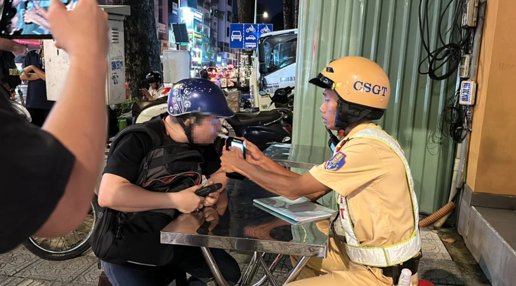 CSGT kiểm tra nồng độ cồn đối với anh L. Ảnh: NGUYỄN YÊN