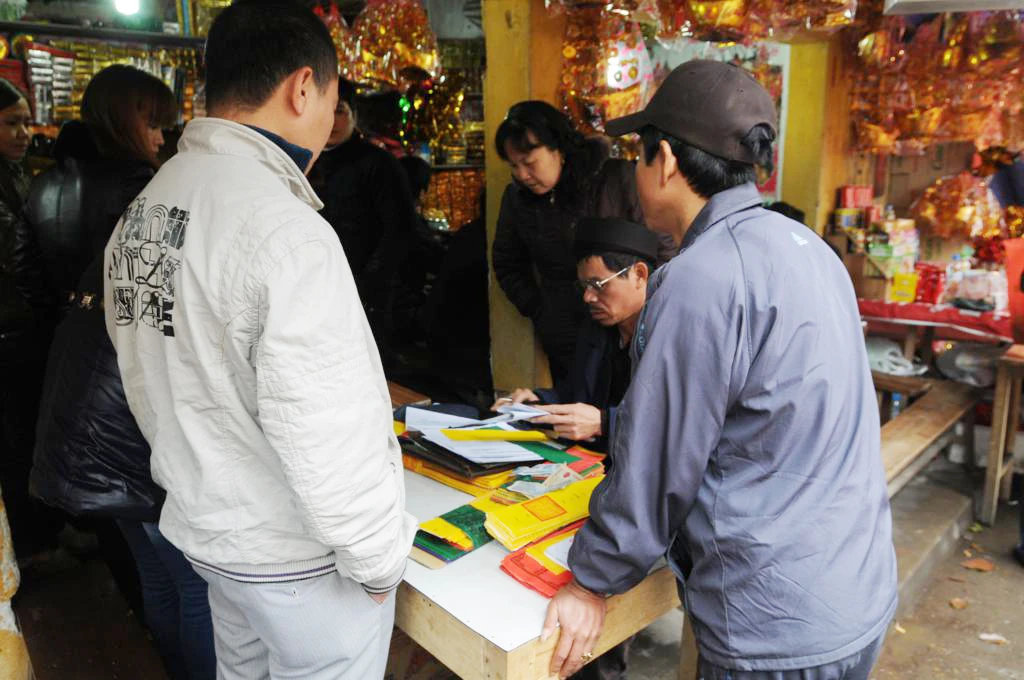 Dọc hai bên đường san sát các hàng quán với dịch vụ viết sớ, sắp lễ 