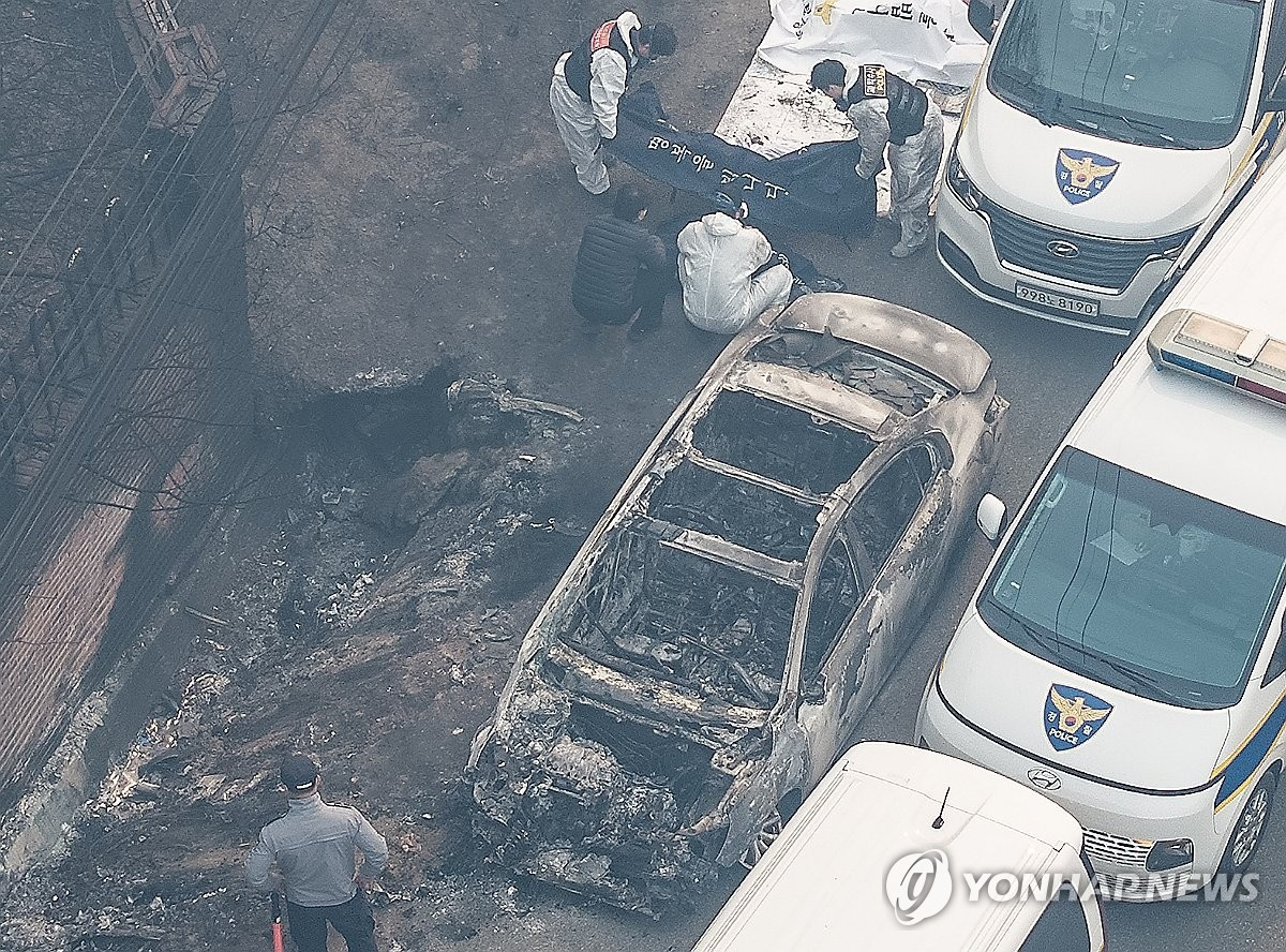 Lực lượng chức năng phát hiện thi thể trong chiếc xe cháy xém. (Ảnh: Yonhap) Lực lượng chức năng phát hiện thi thể trong chiếc xe cháy xém. (Ảnh: Yonhap)
