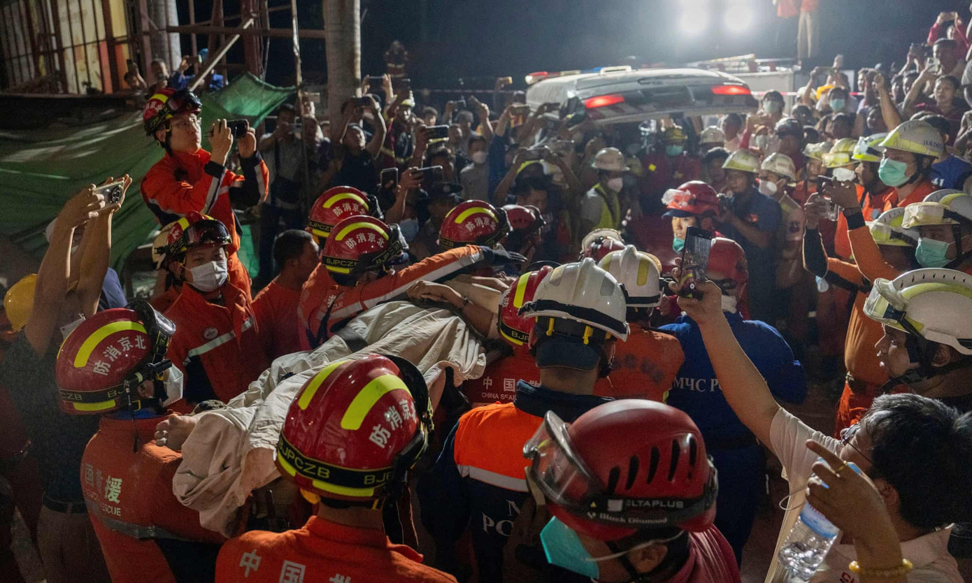 Người phụ nữ được đưa ra ngoài sau khi mắc kẹt suốt 60 giờ. (Ảnh: AP) Người phụ nữ được đưa ra ngoài sau khi mắc kẹt suốt 60 giờ. (Ảnh: AP)