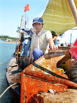  Chủ tàu Trần Văn Quang và chiếc mỏ neo bị tàu Trung Quốc đâm lút vào mũi tàu. Ảnh: Đức Nguyễn