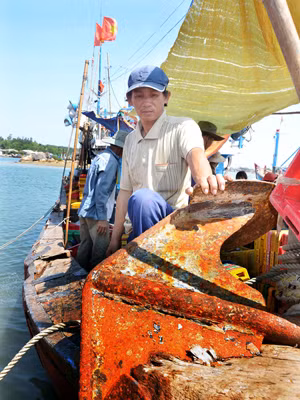  Chủ tàu Trần Văn Quang và chiếc mỏ neo bị tàu Trung Quốc đâm lút vào mũi tàu. Ảnh: Đức Nguyễn