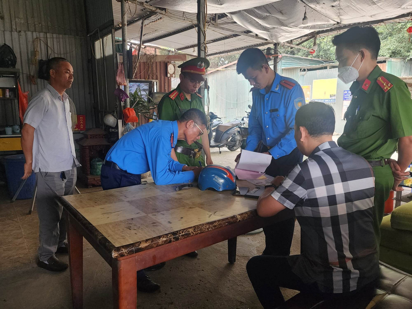 Đoàn liên ngành lập biên bản vi phạm hành chính đối với ông Bùi Văn Tâm do trông giữ xe khi chưa được cấp phép.