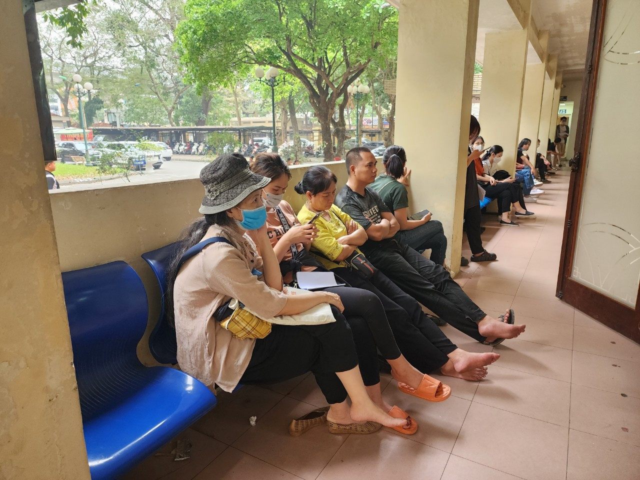 Nhiều người ngồi ngoài hành lang chờ đến lượt.