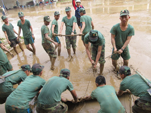 Đẩy bùn ra khỏi sân trường