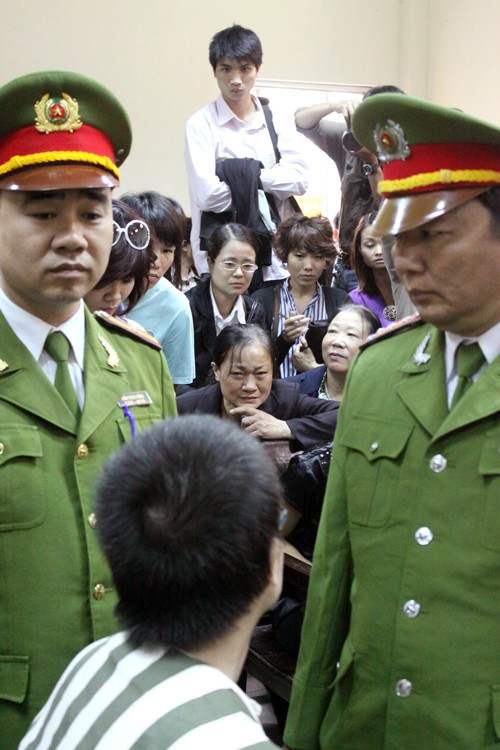 Trong lúc nghị án, Nghĩa cố gắng quay xuống động viên mẹ