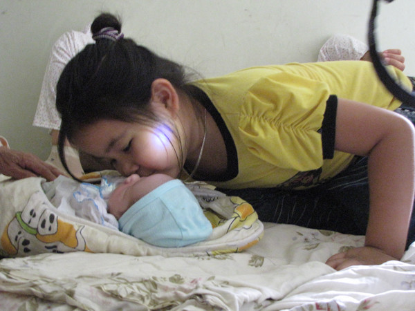 Cháu Ngân - con lớn anh Chiều lao vào thơm cháu Trường. Ảnh: Trường Phong