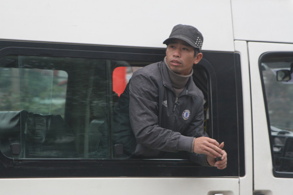 Một lơ xe thò hẳn nửa người ra ngoài xe để mời khách