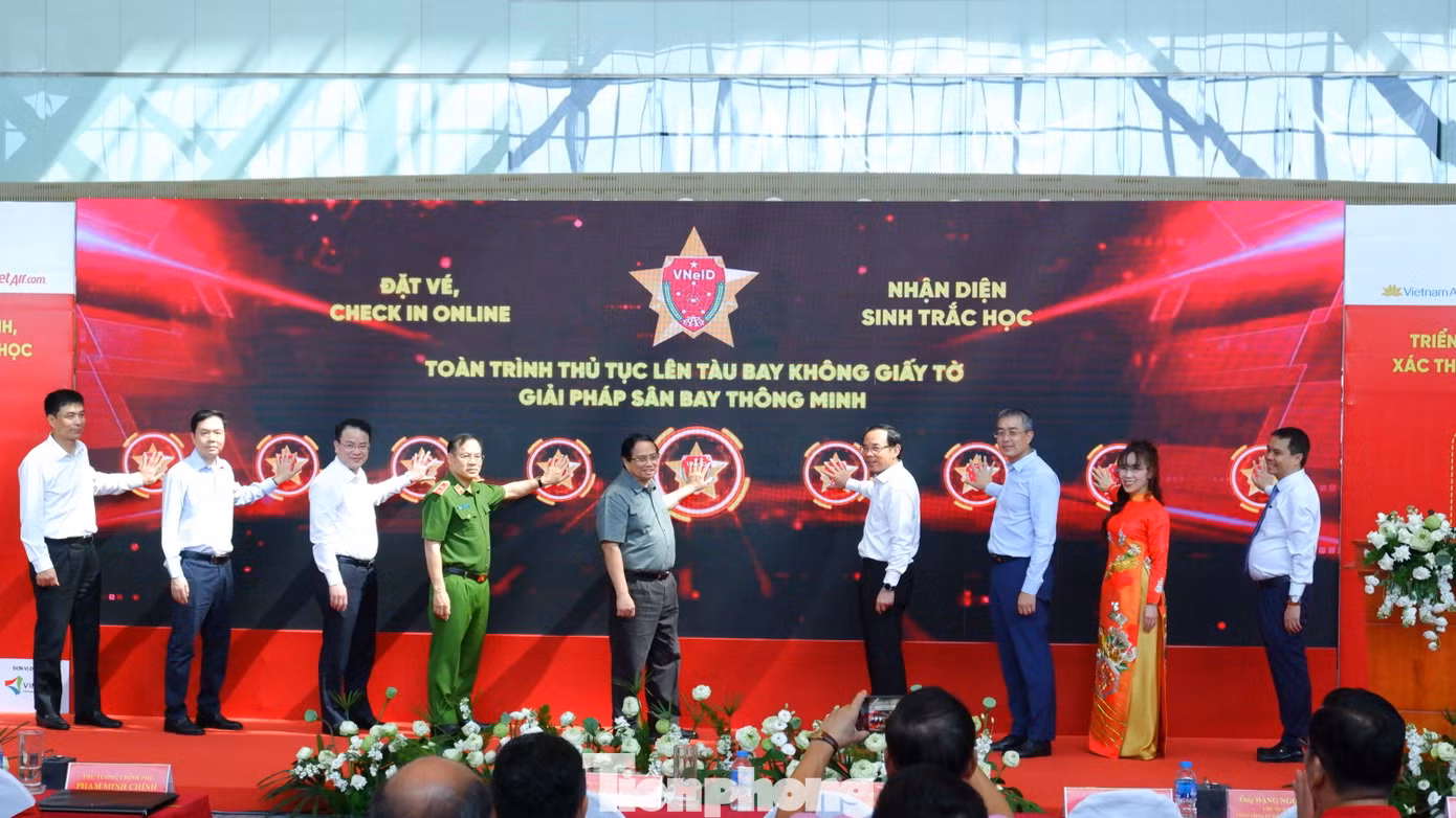 Thủ tướng Phạm Minh Chính và các đại biểu thực hiện nghi thức triển khai giải pháp ứng dụng định danh điện tử và nhận diện sinh trắc học phục vụ thủ tục lên tàu bay ở ga hành khách T3 Tân Sơn Nhất. Ảnh: Hữu Huy.