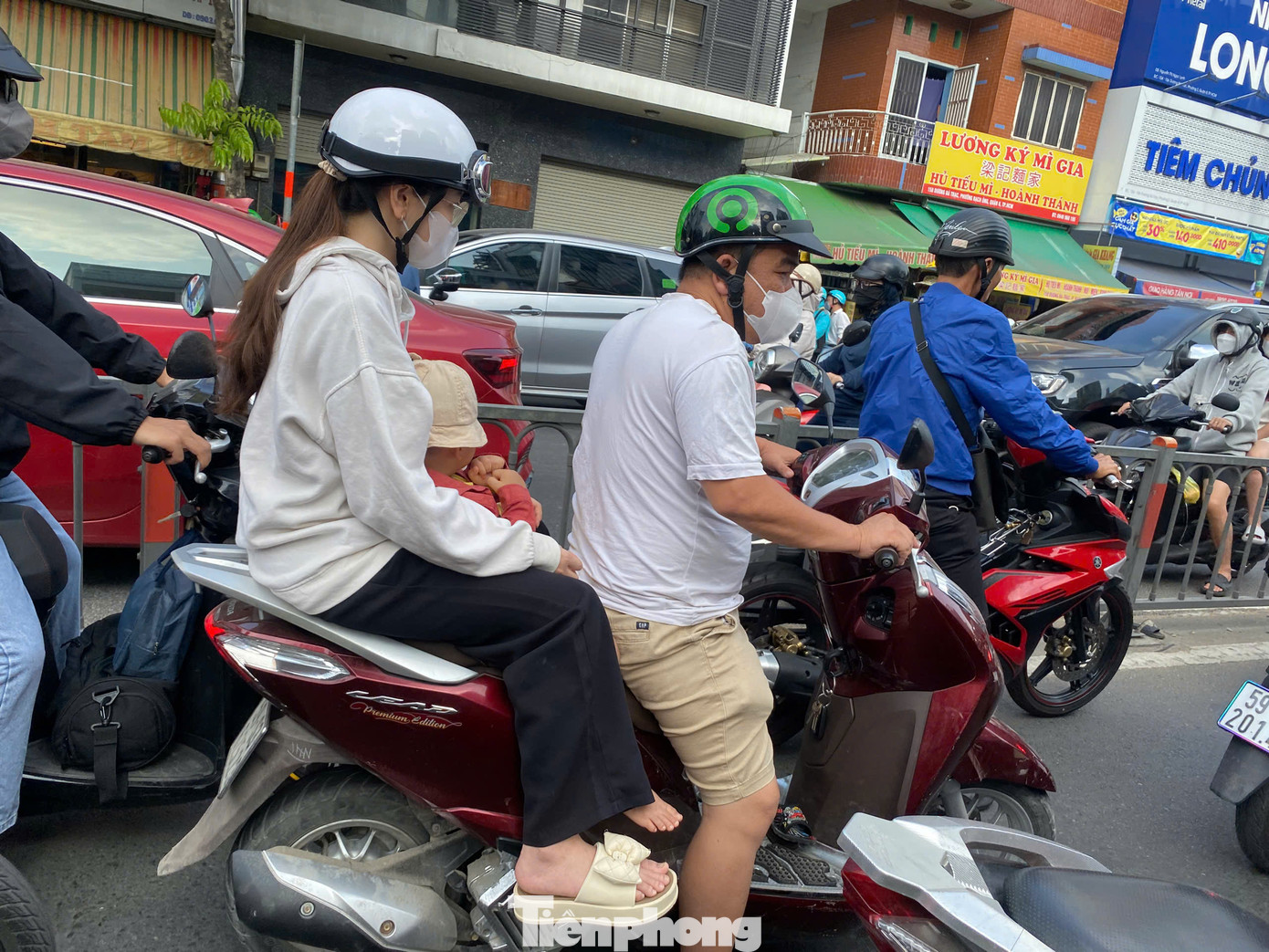 Người và phương tiện nhích từng chút một để lên cầu Nguyễn Văn Cừ đi vào quận 1.