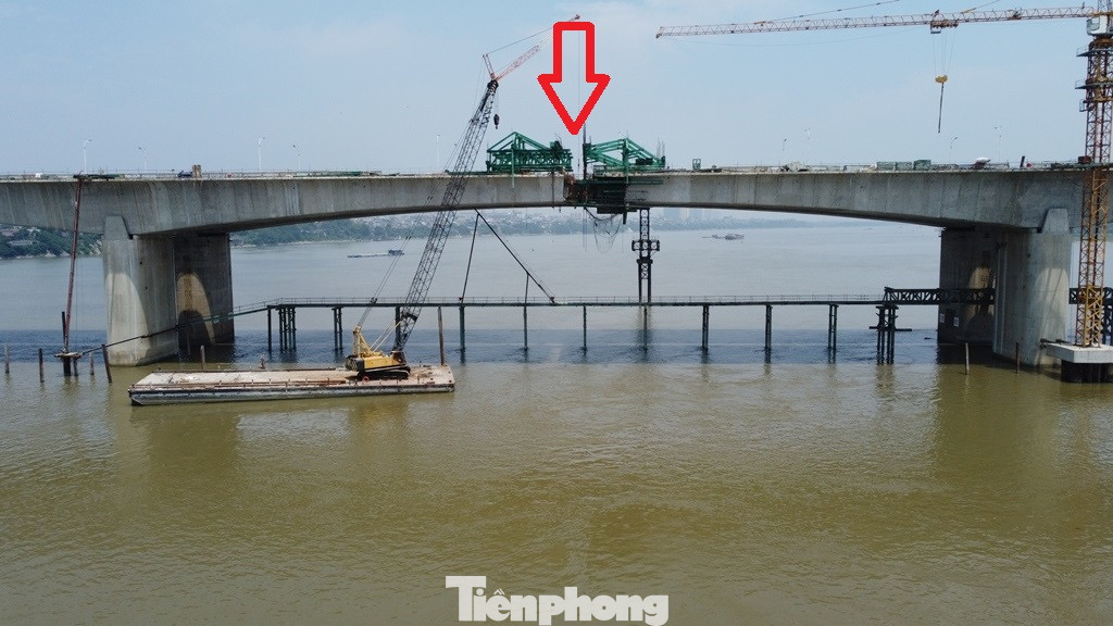 Đoạn tiếp giáp giữa 2 đoạn dầm cầu khi được thi công ở hai bên đuổi lại (mũi tên đỏ). Ngày 30/5 tới, khu vực còn hở này sẽ được hợp long (khớp nối với nhau).