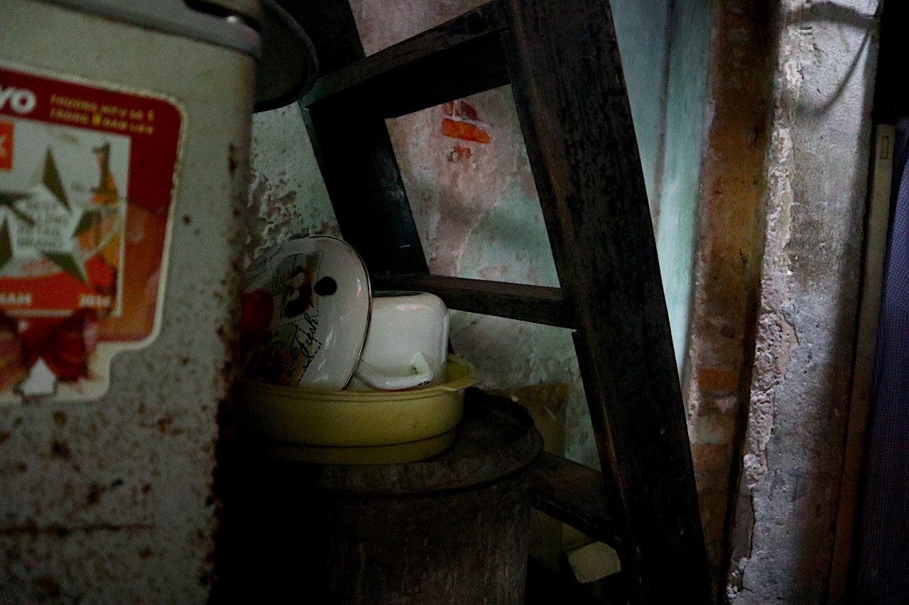 Trong căn nhà diện tích chưa tới 5m2 cho 4 người lớn của ba thế hệ sinh hoạt, việc nấu ăn, tắm rửa, vệ sinh phụ thuộc hoàn toàn vào không gian của nhà anh trai bà Nghĩa ở tại căn nhà kế bên với hai chục người sinh hoạt mỗi ngày.