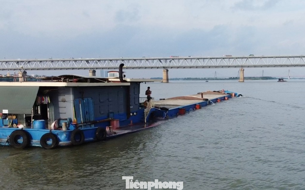 Tàu chở cát chìm cả mớn nước an toàn (quá tải) và một phần mạn sàn tàu, trên sông Hồng chiều 14/5. Tàu chở cát chìm cả mớn nước an toàn (quá tải) và một phần mạn sàn tàu, trên sông Hồng chiều 14/5.