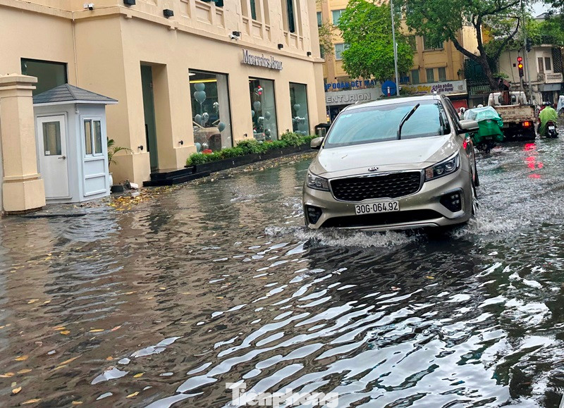 Trên phố Đặng Thái Thân (quận Hoàn Kiếm), mưa ngập cả vỉa hè.