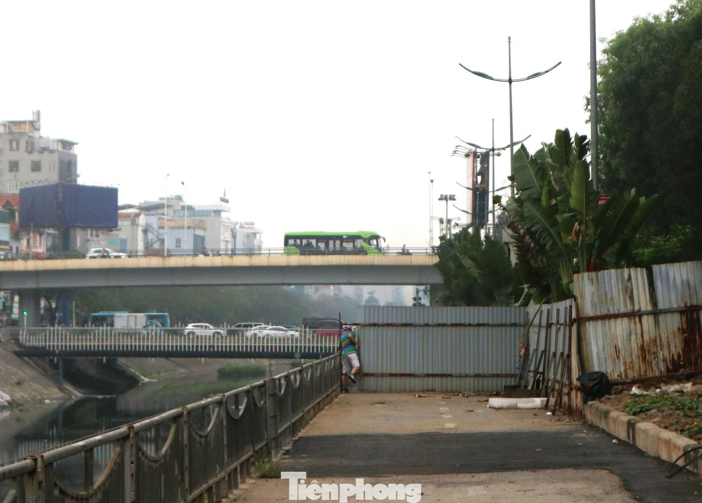 Người dân phải trèo qua các rào chắn để đi bộ thể dục tại khu vực tuyến đường.