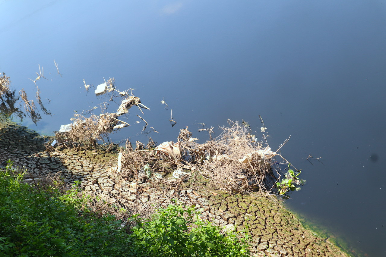 Bùn nổi thành ụ cao dọc sông Đáy tại khu vực Biên Giang (Hà Đông). Cũng như các con sông khác ở nội thành Hà Nội, dòng nước đen và bốc mùi hôi thối là đặc trưng của dòng sông này.