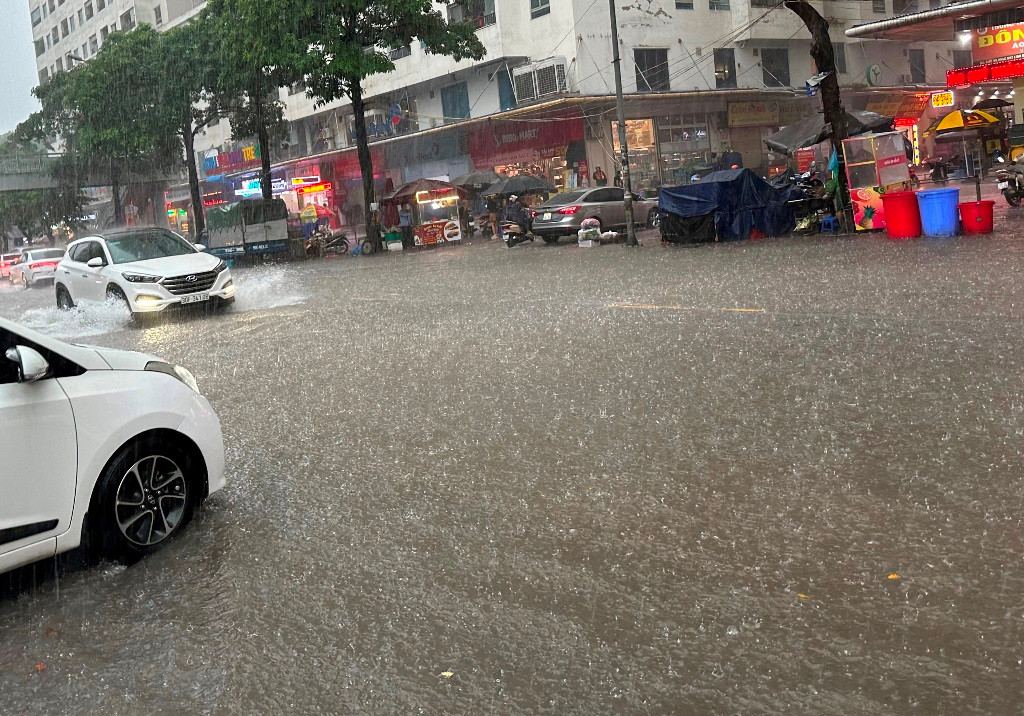 Trên các phố Nguyễn Hữu Thọ, Giải Phóng, Linh Đường, Định Công... nước ngập sâu. Nhiều xe máy, ô tô gầm thấp không dám đi qua.
