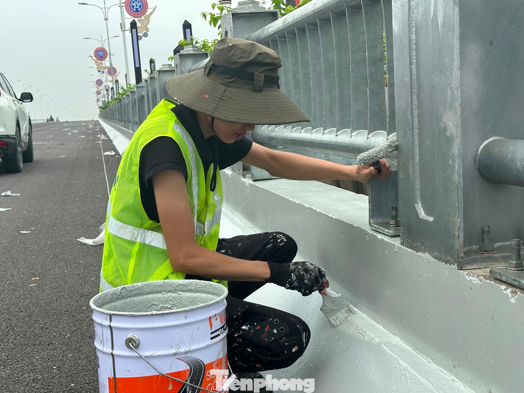 Sau khi thảm nhựa xong mặt cầu, các đơn vị thi công tập trung các hạng mục hoàn thiện cầu, như: Kẻ vạch đường, sơn phun áo, phản quang tường chắn, lắp thiết bị chiếu sáng...