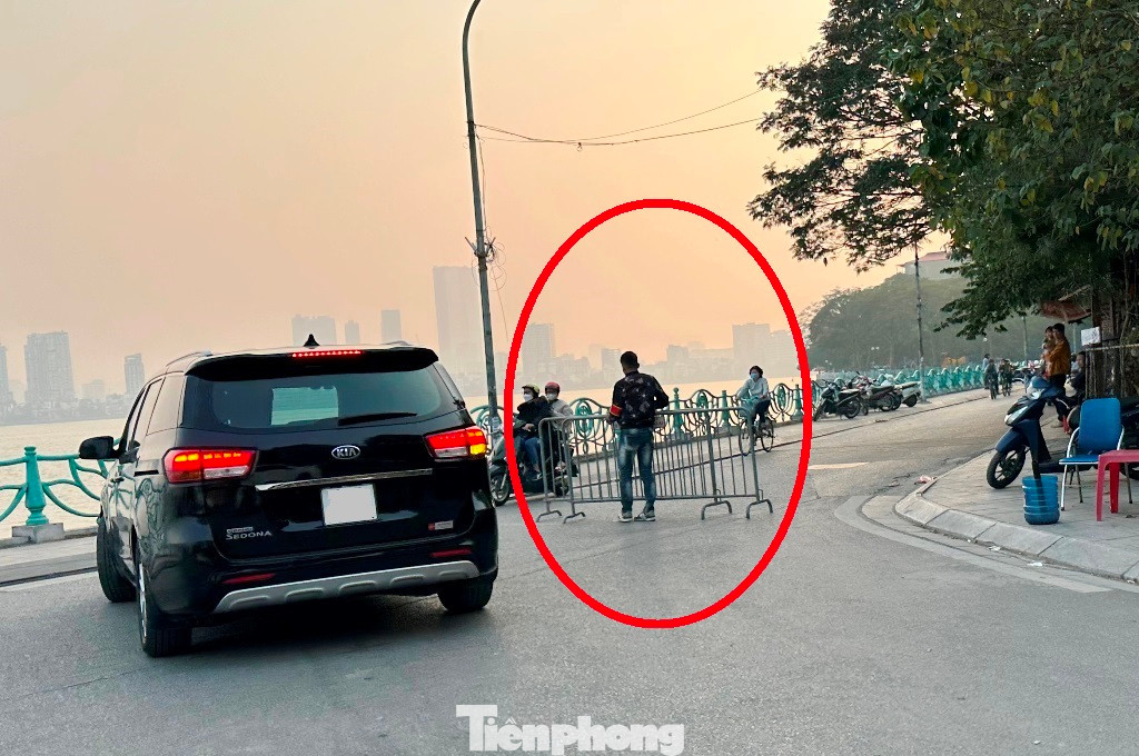 Tại các bãi xe trên phố Đặng Thai Mai, nhân viên bãi xe có đeo băng đỏ (vòng tròn) dùng cả hàng rào barie có gắn chữ "Công an Hà Nội" để chặn đường ven Hồ Tây trái phép, buộc lái xe phải vào bãi gửi xe. Tại các bãi xe trên phố Đặng Thai Mai, nhân viên bãi xe có đeo băng đỏ (vòng tròn) dùng cả hàng rào barie có gắn chữ "Công an Hà Nội" để chặn đường ven Hồ Tây trái phép, buộc lái xe phải vào bãi gửi xe.