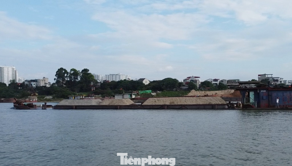 Có mặt trên đoạn sông từ cầu Thăng Long hướng dẫn lên Ba Vì trong ngày 14/5, phóng viên ghi nhận, hàng chục tàu trong đó có tàu TH-0315 như trong ảnh chở cát có ngọn, chìm cả mớn nước an toàn chạy vào hướng nội đô.