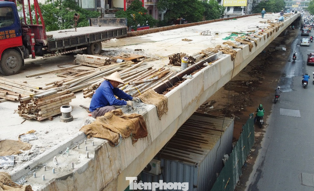Công việc trên mặt cầu đang được công nhân thực hiện mấy ngày qua là đắp bờ vỉa để dựng các thanh lan can hai bên cầu.