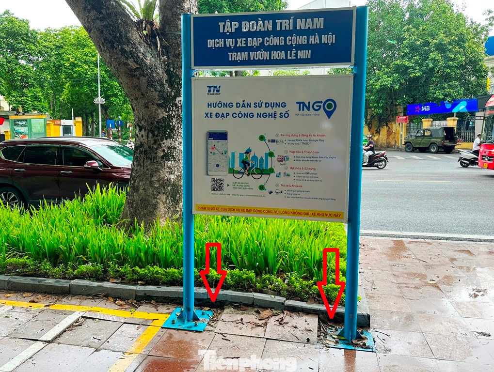Tại trạm xe đạp công cộng ở Công viên Lê Nin (Ba Đình), bản chỉ dẫn ở đây sau khi được nhà đầu tư cho chôn cột xong đang có hiện tượng lún vỉa hè.