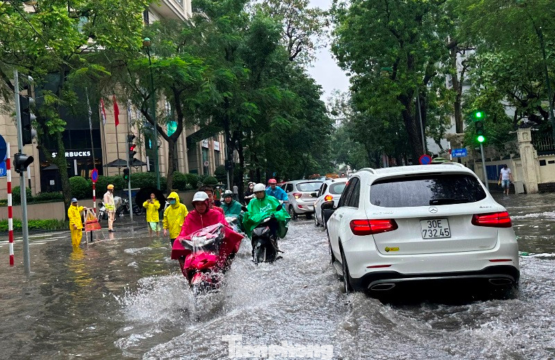 Đến hơn 10h sáng nay, CSGT và nhân viên Cty Thoát nước vẫn tiếp tục chốt trực trên một số tuyến phố ngập nước để hướng dẫn giao thông và khơi thông miệng hố ga để nước mưa rút nhanh hơn.