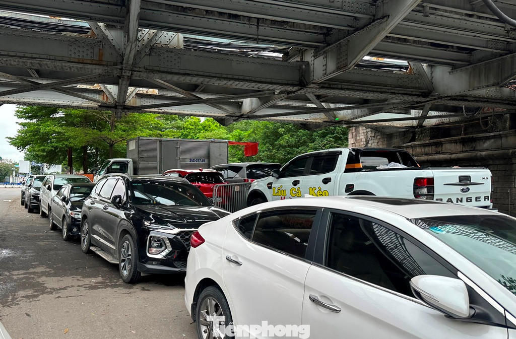 Ngoài trông ô tô trái quy định trong bãi xe máy, hiện ô tô gửi tại bãi xe gầm cầu Long Biên phía quận Hoàn Kiếm còn đỗ tràn ra cả lòng đường. Ngoài trông ô tô trái quy định trong bãi xe máy, hiện ô tô gửi tại bãi xe gầm cầu Long Biên phía quận Hoàn Kiếm còn đỗ tràn ra cả lòng đường.