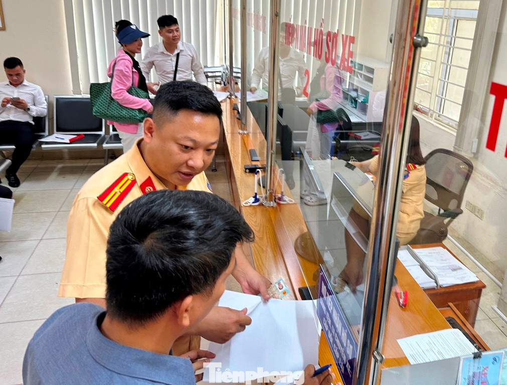 Sáng 24/7, Thiếu tá Tạ Quang Minh, Tổ trưởng Cơ sở đăng ký xe số 2 - đường Láng (người mặc sắc phục, đeo quân hàm) đã cơ động đến xử lý một số hồ sơ, không để người dân phải chờ đợi quá lâu.