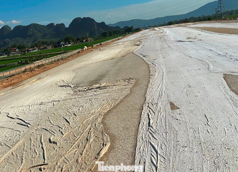 Nhiều đoạn mặt đường đang phải phủ vải giữ nước chống nứt, lún.