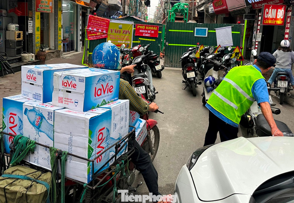 Với những xe máy chở theo hàng thì không thể nào leo lên vỉa hè, "chui" hàng rào để di chuyển qua công trường.