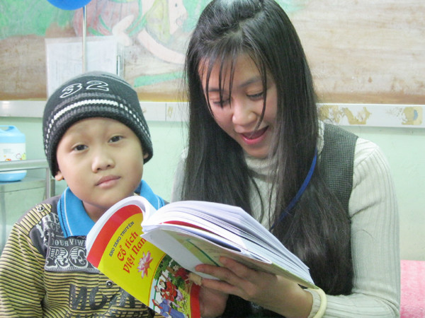 Không xuống lớp học được, bệnh nhi được tình nguyện viên lên tận giường bệnh đọc truyện cho nghe