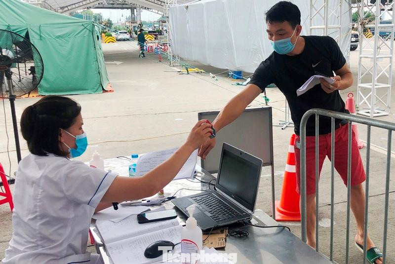 Sau khi hệ thống camera đọc xong mã QR, nhân viên y tế theo dõi sẽ được họ đóng một dấu "xác nhận" vào tay chủ phương tiện để "thông chốt".