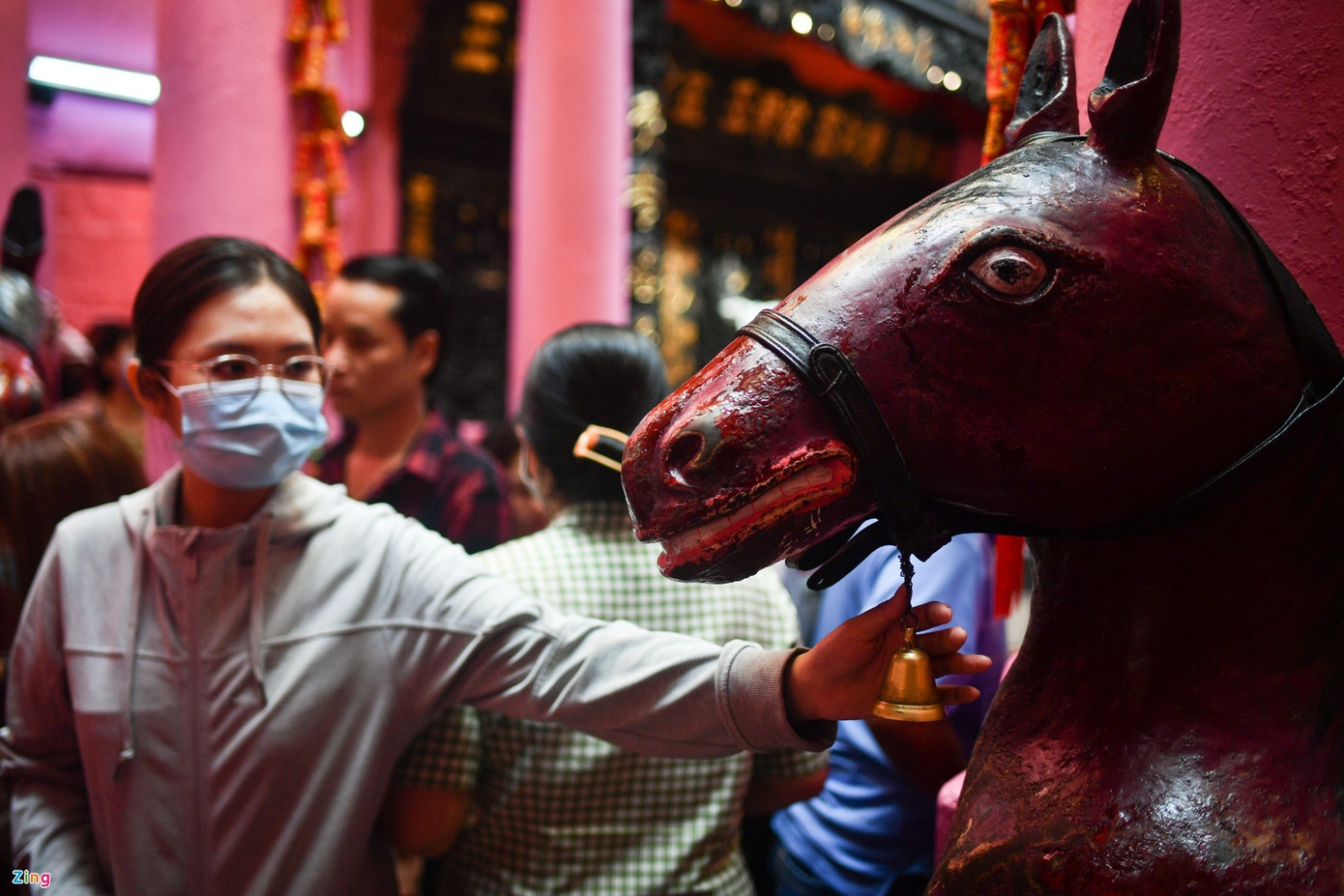 Đình Thần Tài đông nghẹt người xếp hàng ra vào trong không gian nhỏ hẹp. Ai cũng muốn được rung chuông trên tượng ngựa Xích Thố nhằm cầu may, bình an.