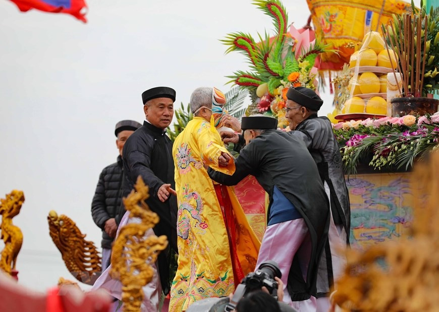 Cụ cao niên ở Đọi Sơn được làm lễ nhập linh khí Vua Lê Đại Hành, khoác long bào, đeo mặt nạ (hóa thân thành Vua) bắt đầu nghi lễ Tịch điền. (Ảnh: Thanh Tùng/TTXVN)