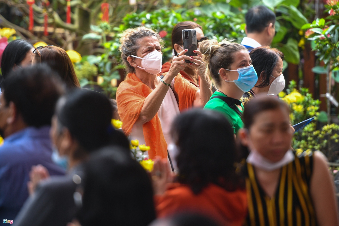 Khuôn viên được trang trí đậm chất Tết với hàng loạt dây treo lồng đèn, hoa mai rực rỡ và hình dán đầy đủ ý nghĩa. Một số du khách sau khi dâng lễ xong nán lại để vãn cảnh, chụp hình.