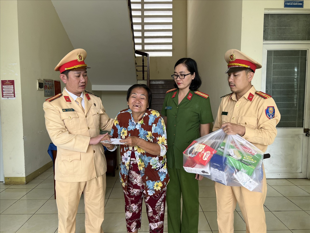 Các đồng chí Cảnh sát giao thông trao lộ phí và vật dụng thiết yếu để ba bà cháu lên xe về Bà Rịa - Vũng Tàu.