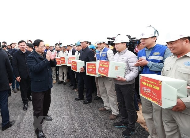 Thủ tướng Phạm Minh Chính động viên, chúc mừng năm mới tới kỹ sư, công nhân thi công nút giao Đông Xuân thuộc Dự án thành phần cao tốc Mai Sơn - Quốc lộ 45. (Ảnh: Dương Giang/TTXVN)