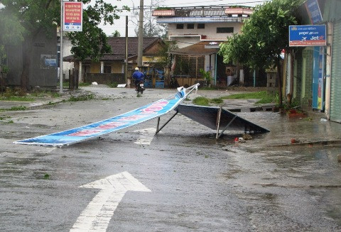 Biển quảng cáo bị gió thổi nhào ra giữa phố. 