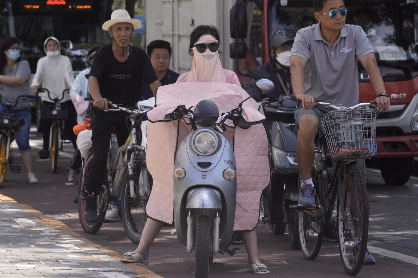Một phụ nữ ở Trung Quốc che kín để tránh nắng nóng vào tháng 7 này. Ảnh: Ng Han Guan/ AP.
