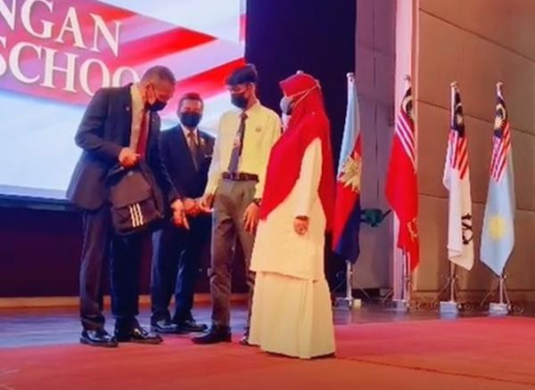 Bộ trưởng Quốc phòng Malaysia chỉ cho nam sinh thấy là dây giày của cậu bị tuột. Ảnh: Facebook. Bộ trưởng Quốc phòng Malaysia chỉ cho nam sinh thấy là dây giày của cậu bị tuột. Ảnh: Facebook.