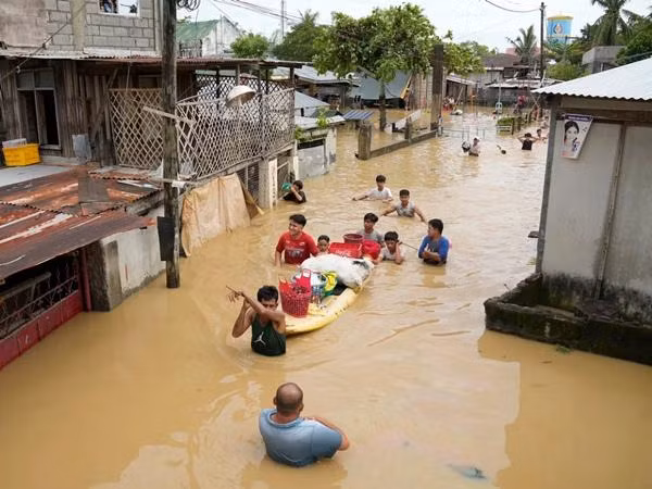 Người dân Bulacan (Philippines) lội trên đường phố ngập lụt. Ảnh: Aaron Favila/ AP.