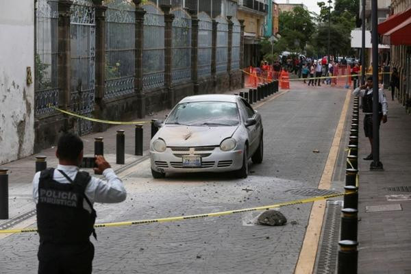 Cảnh sát chụp ảnh một chiếc xe bị đá rơi vào trong trận động đất ngày 19/9/2022. Ảnh: Fernando Carranza/ Reuters.