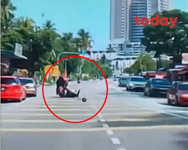 Người ngồi sau xe máy bị ngã lăn ra đường do quả dừa rơi trúng đầu. Ảnh: Today.