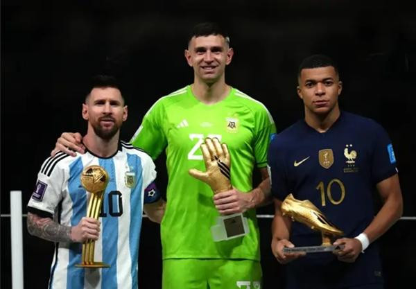 Mbappe không cười khi cầm giải thưởng Chiếc Giày Vàng (Vua phá lưới) chụp ảnh cùng Messi và Martinez. Ảnh: Alamy.