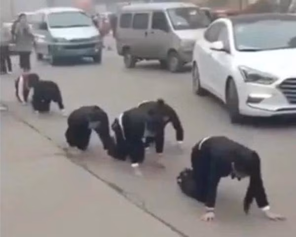 Nhóm nhân viên của một công ty ở Sơn Đông (Trung Quốc) từng bị bắt bò trên phố vì không đạt KPI. Ảnh: DW.