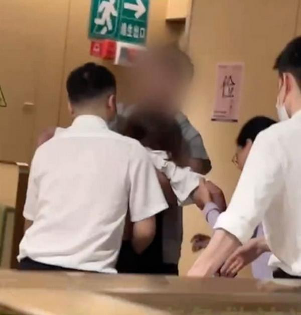 Nhân viên nhà hàng cố gắng giúp nữ thực khách. Ảnh: Weibo.