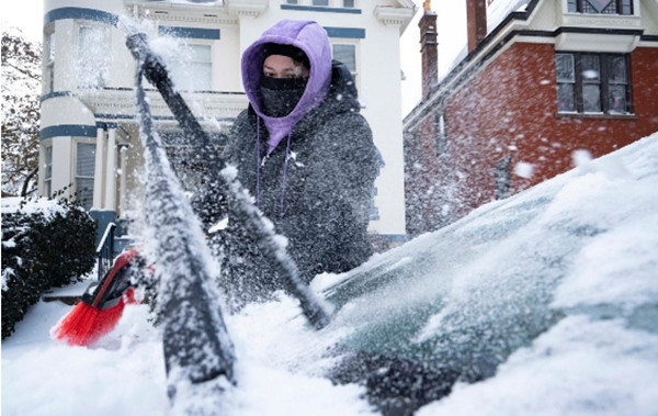 Một người đang cố gạt băng tuyết khỏi xe ô tô của mình. Ảnh: Joseph Scheller/ Columbus Dispatch/ USA Today Network.