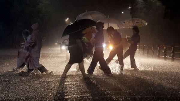 Người dân ở Seoul (Hàn Quốc) vội vã đi bộ dưới trời mưa to. Ảnh: Yonhap/ Reuters. Người dân ở Seoul (Hàn Quốc) vội vã đi bộ dưới trời mưa to. Ảnh: Yonhap/ Reuters.