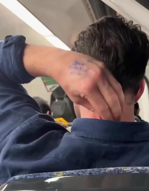 Hành khách có dòng chữ lạ được viết trên tay. Ảnh: Emma Chow.